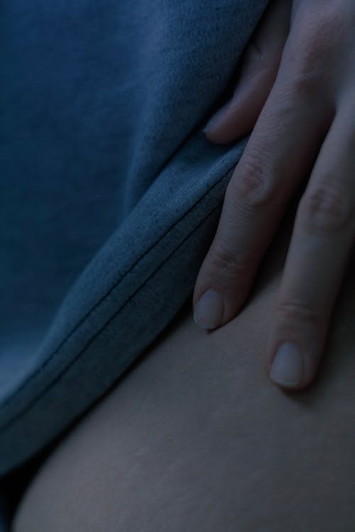 Persons Hand on Blue Textile