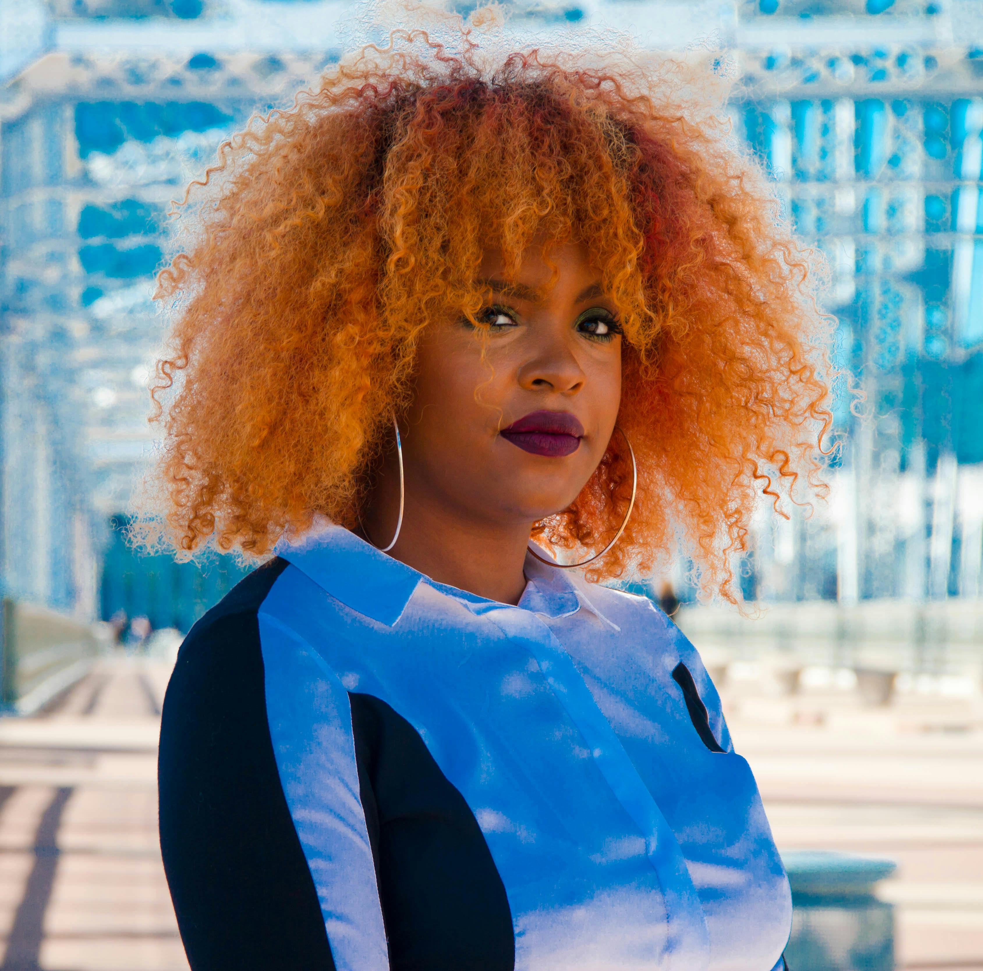 Vibrant portrait of a woman with curly hair and hoops in Nashville.