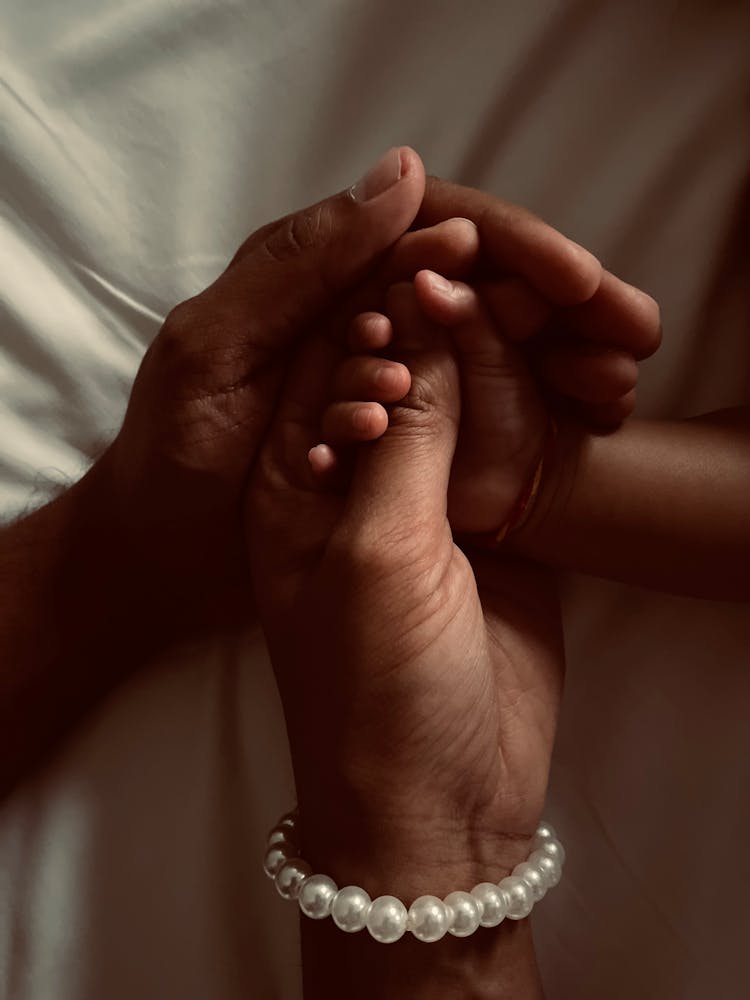 Close-up Of Family Holding Hands Together 