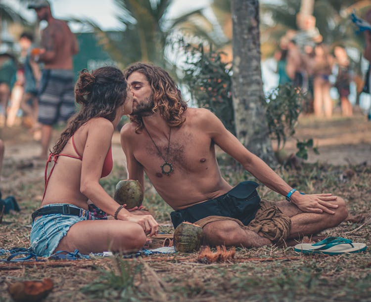 Couple In Tropics Sitting And Kissing 