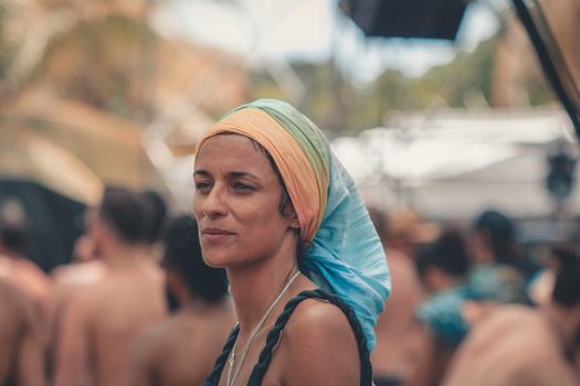 Woman wearing a colorful bandana at an outdoor gathering. Summer vibes.