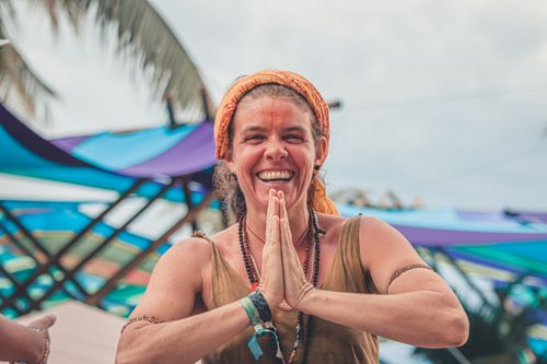 Free Smiling woman in a brown tank top enjoying an outdoor festival with colorful decorations. Stock Photo