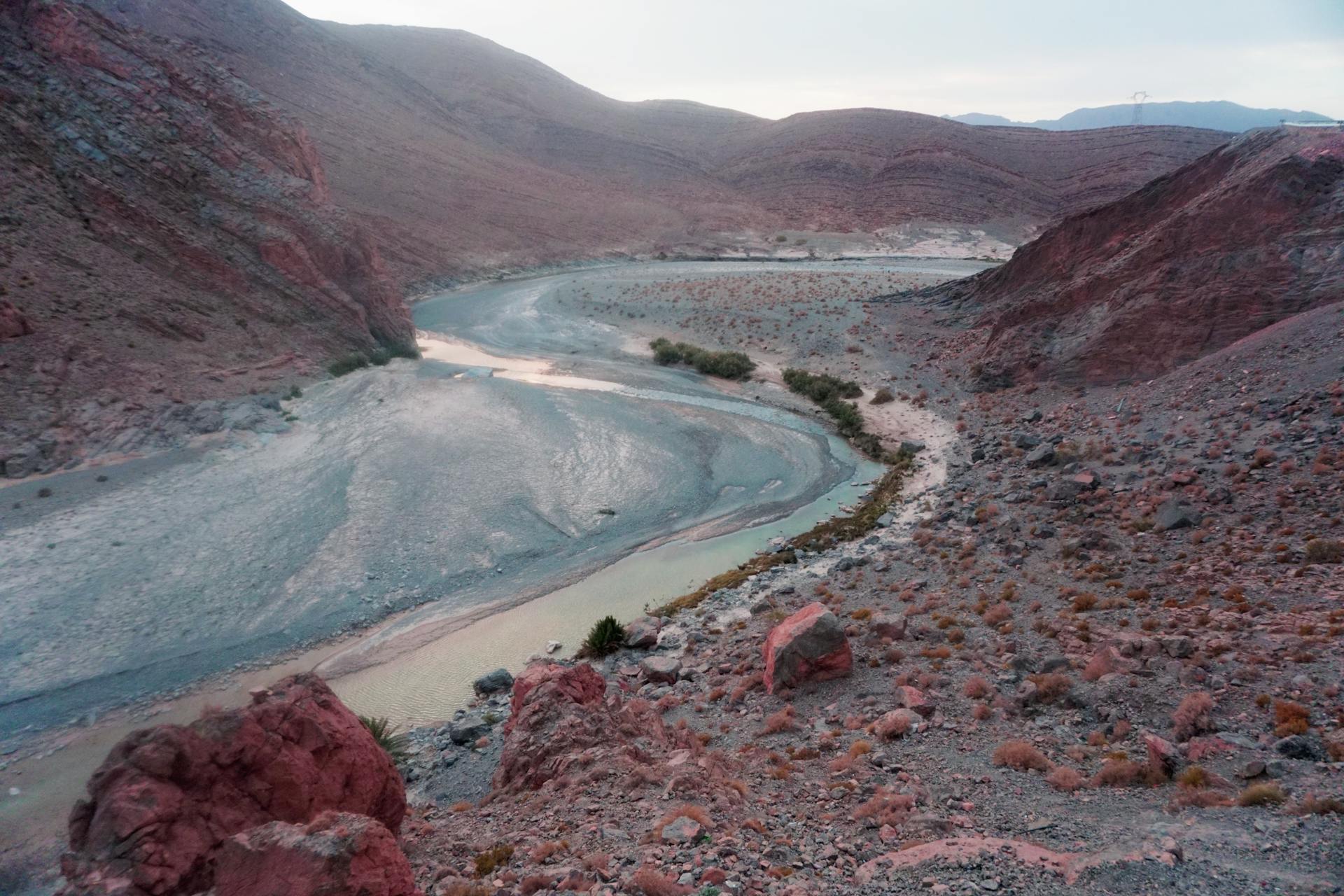 A breathtaking aerial view of the Ziz River winding through the rugged Atlas Mountains landscape.