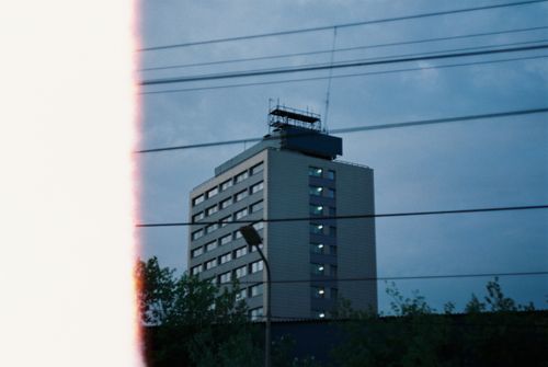Free A modern building in Moscow at twilight with cable wires and trees in the foreground. Stock Photo