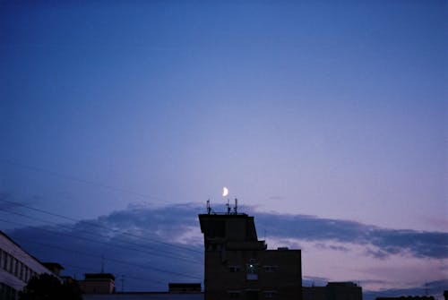 Crescent Moon over House in Evening