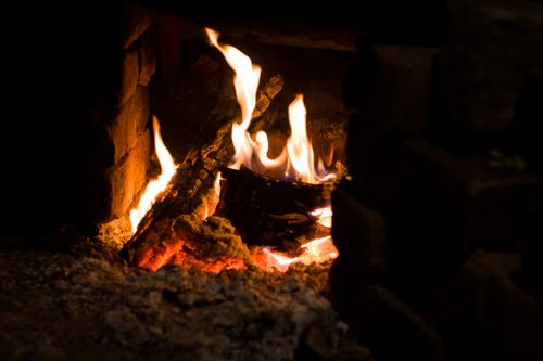 Free A close-up view of a warm fireplace with glowing embers and dancing flames, perfect for a cozy setting. Stock Photo