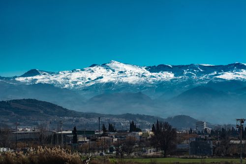Free Snow-capped mountain range with a clear sky and scenic town view, perfect for landscape enthusiasts. Stock Photo