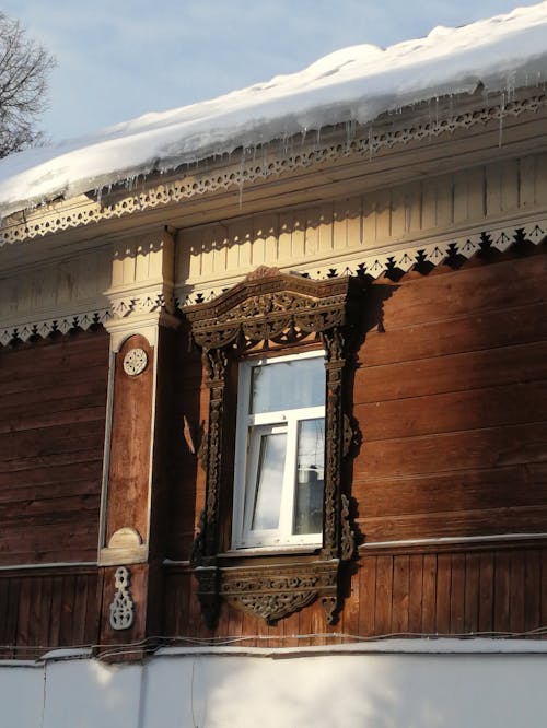 Wooden House Facade with Carved Ornaments Around the Window 