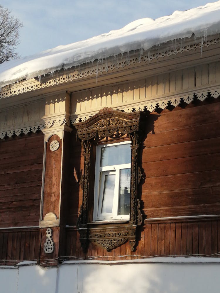 Wooden House Facade With Carved Ornaments Around The Window 