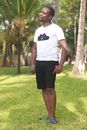 Woman in White Crew Neck T-shirt and Black Skirt Standing on Green Grass Field during