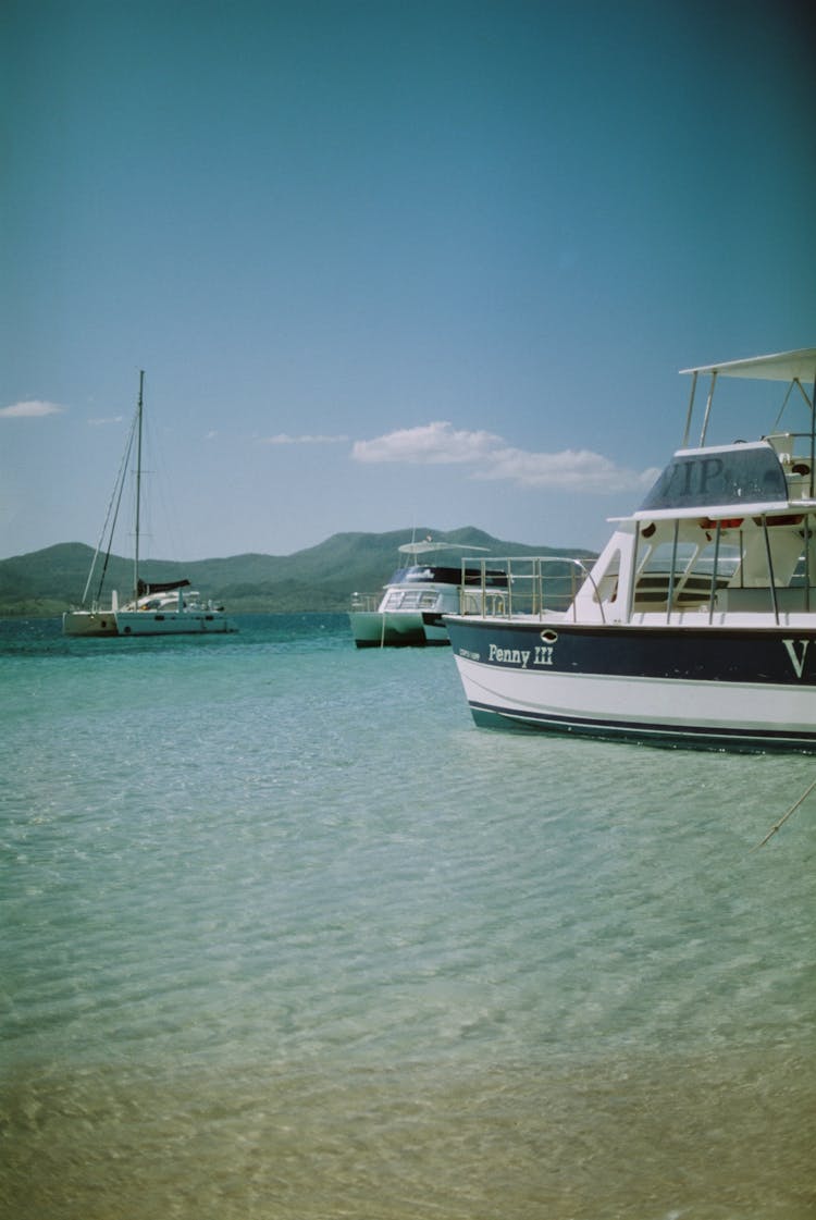 Motorboats And Sailboat Anchored On Sea