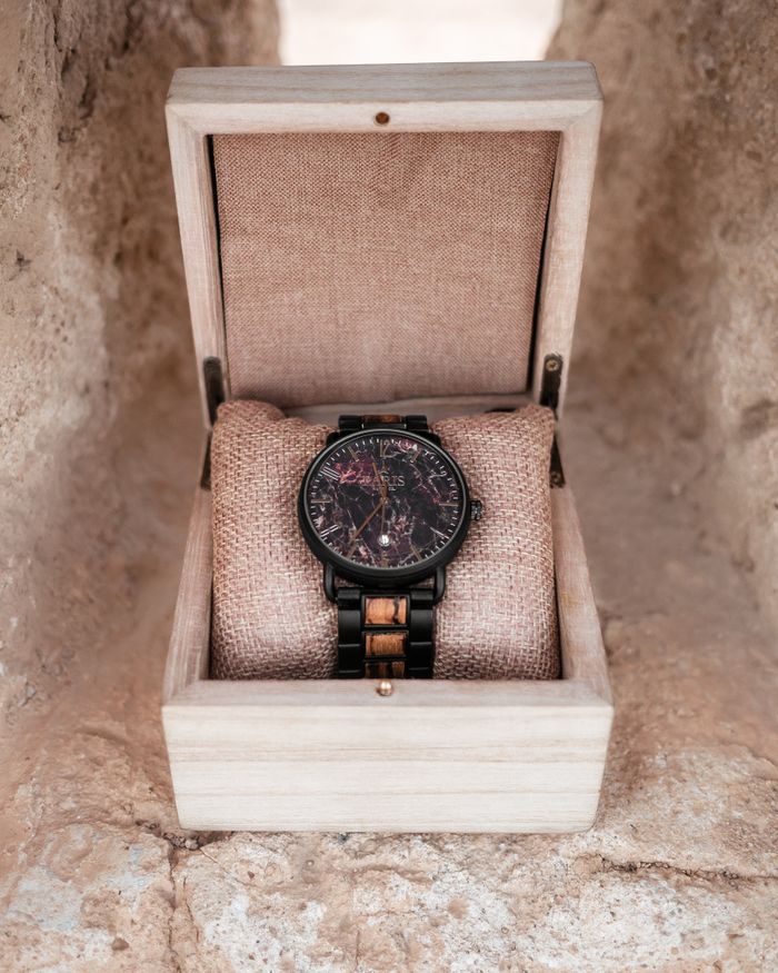 A wristwatch resting in an open wooden presentation box, photo by Ilyas Chabli on Pexels