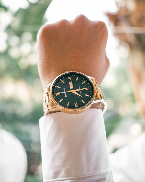 A Close-Up Shot of a Person Wearing a Gold Wristwatch
