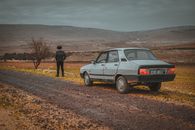 Man in Black Jacket Standing Beside White Suv