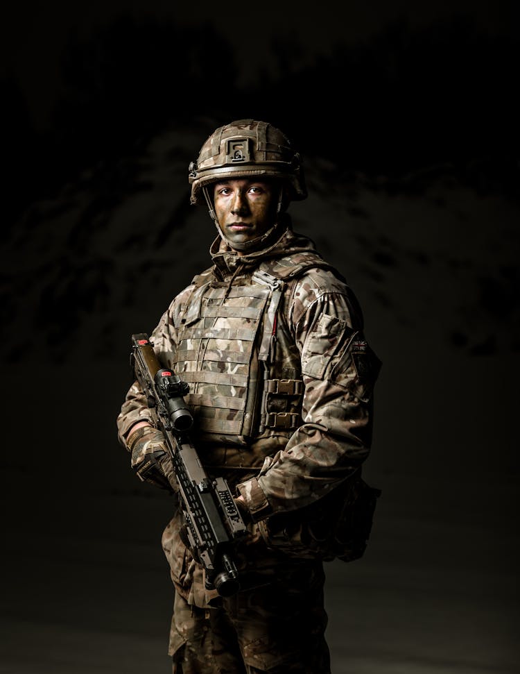 A Military Personnel Holding A Rifle