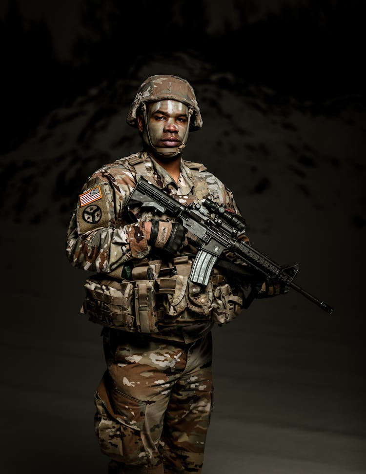 
A Military Personnel Holding A Rifle