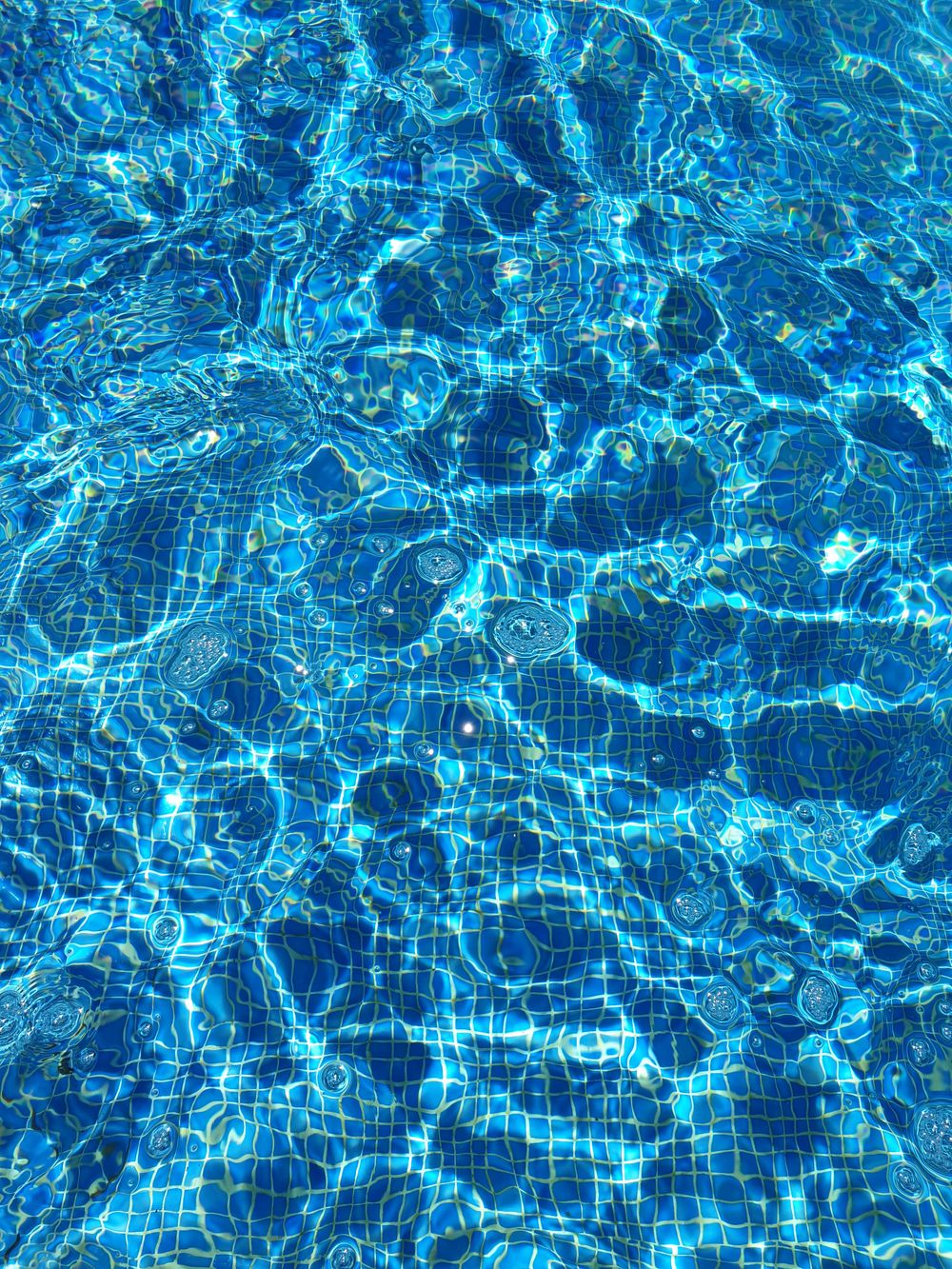 A clean, freshly serviced swimming pool with paved surround
