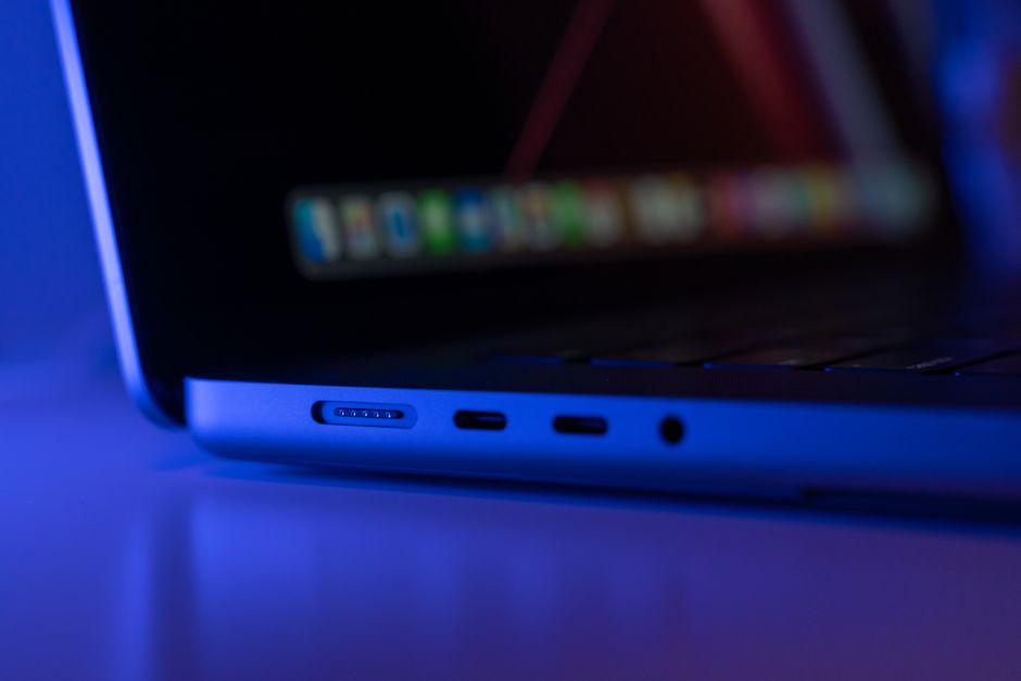 A angled close-up of a sleek laptop with blue ambient lighting highlighting its ports.