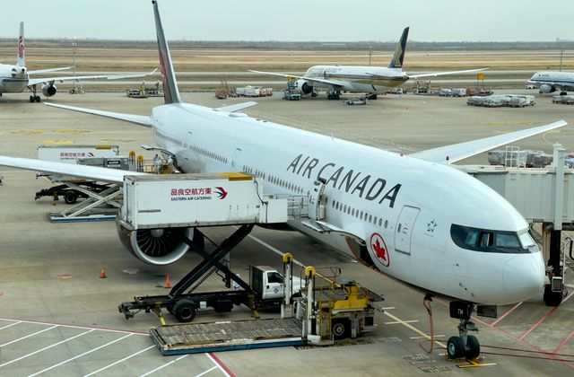 Air Canada airplane being serviced at Shanghai Pudong Airport. Busy tarmac with multiple aircraft. — arriving in Shanghai