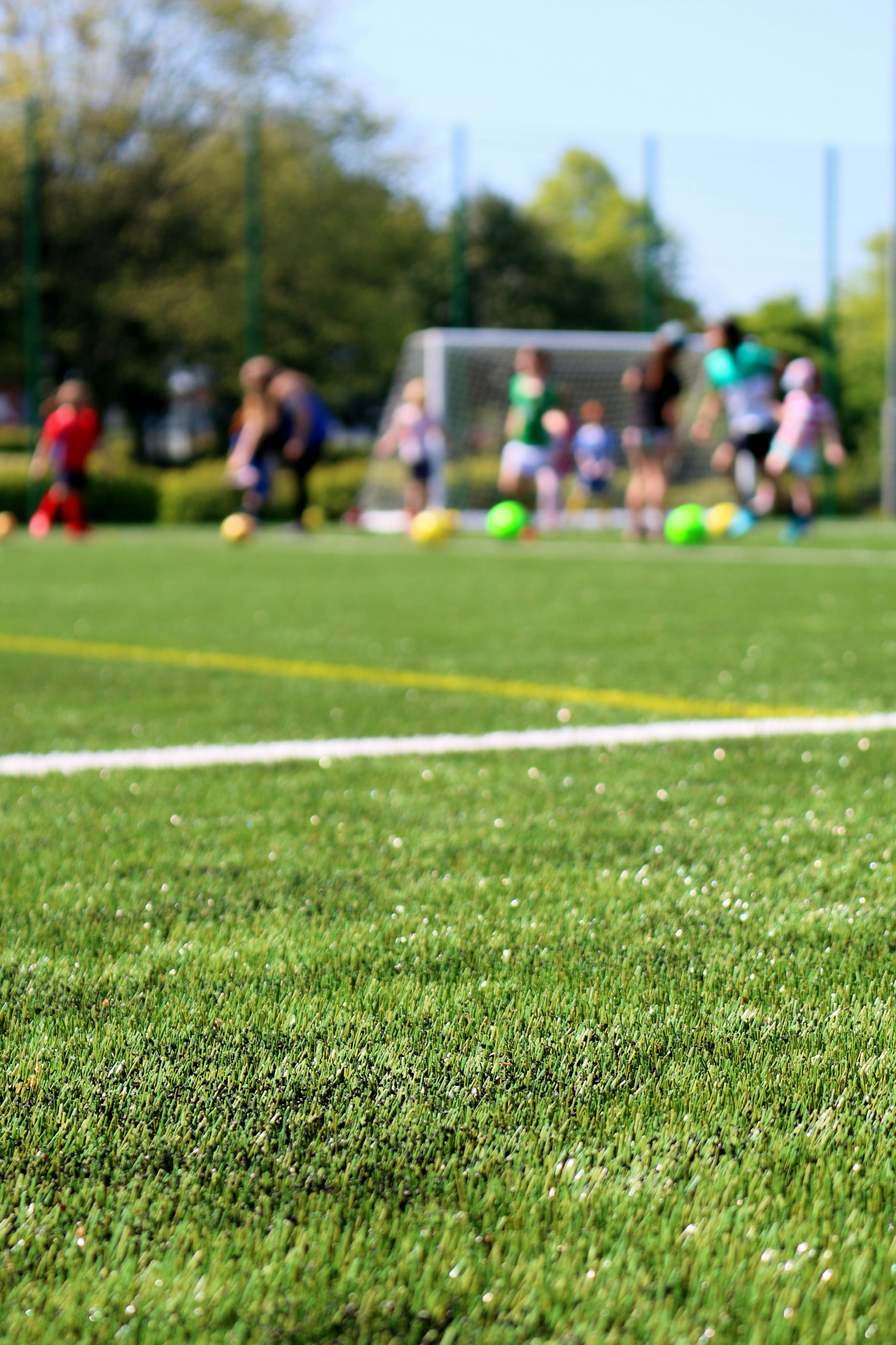 people playing soccer in the grass field