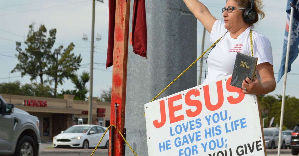 Preaching Sign Street Preacher Standing next to a Cross with Signs · Free Stock Photo