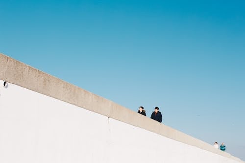 Four Person Wearing Jacket Under White Cloud Blue Skies