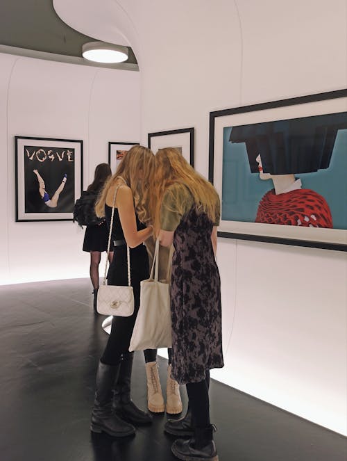 Women Standing near a Painting inside an Art Gallery