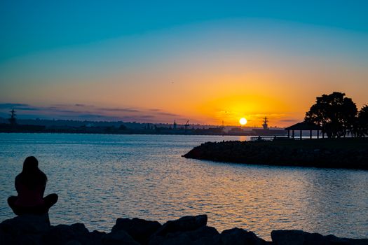 夕阳西下，宁静的湖面映出剪影，水面泛起橙色的光芒