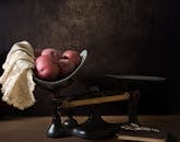 复古平衡秤搭配红色土豆和蕾丝布，营造出质朴的怀旧感