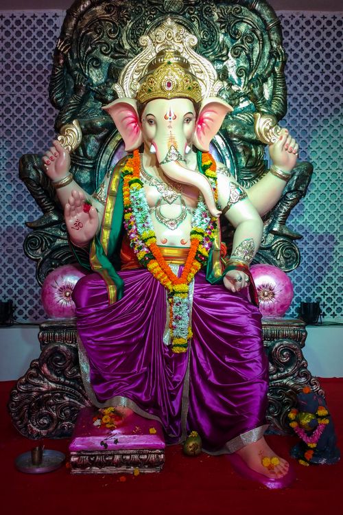 Free Colorful statue of Hindu deity Ganesha adorned with flowers, symbolizing prosperity and wisdom. Stock Photo