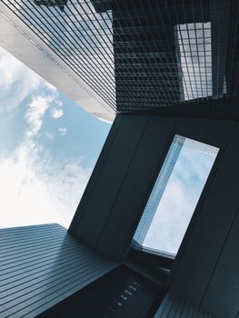 Contemporary architectural shot highlighting glass facades and reflections under a bright sky.