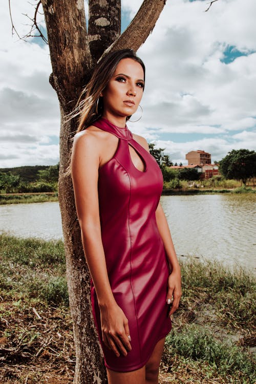 Woman Wearing Red Sleeveless Dress Standing Near Tree