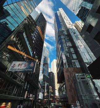 Dynamic downtown cityscape with towering skyscrapers under a bright blue sky.