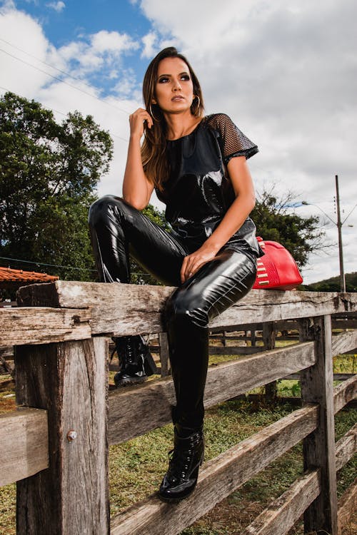 無料 フェンスに座っている農場で黒いスーツを着ている女性 写真素材