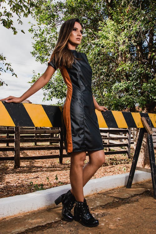 Woman Wearing Black and Brown Leather Midi Dress and Black Chunky Heeled Boots