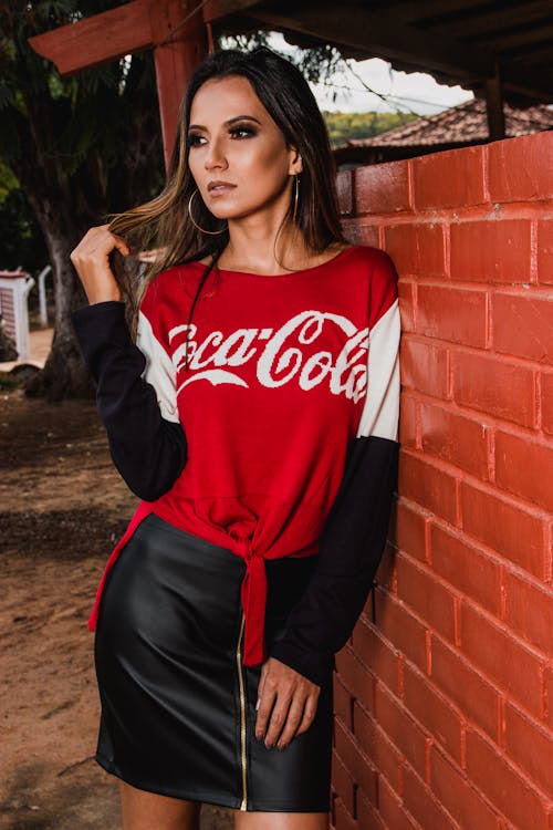 Woman Wearing Black, White, and Red Coca-cola Long-sleeved Shirt and Mini Skirt