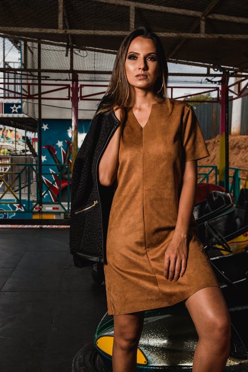 Photo Of Woman In Brown Mini Dress Holding Black Jacket