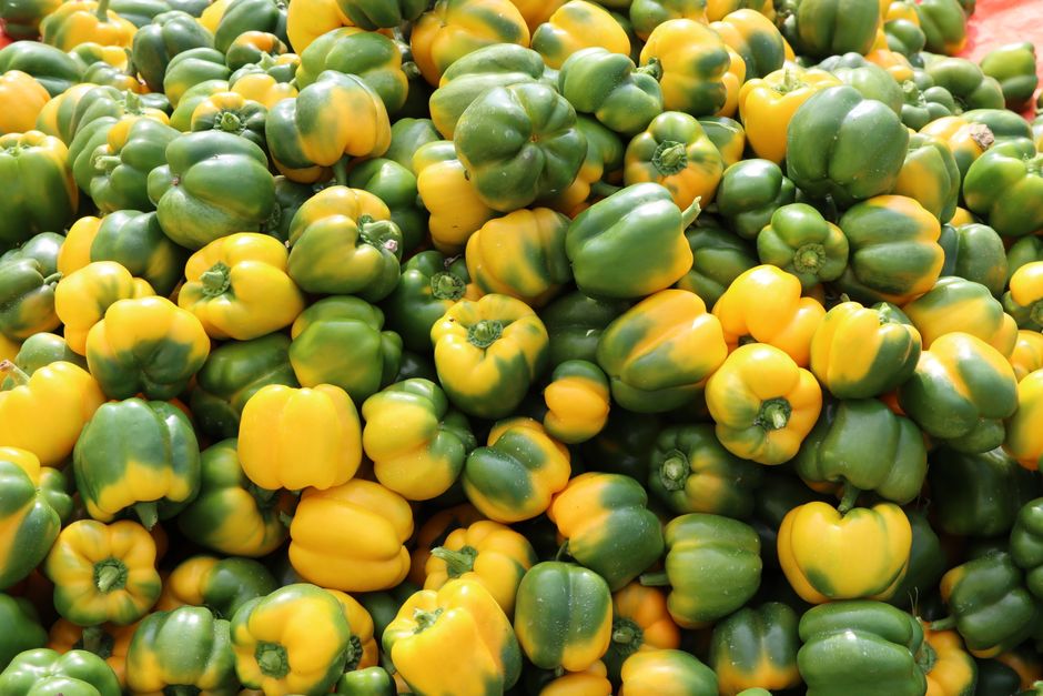 Pasas amarillas y pimentones rojos frescos en mercado de frutas y verduras
