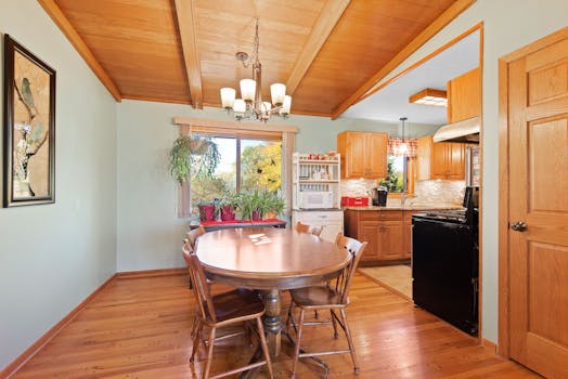 A warm dining room with wooden furniture and natural light offers a cozy atmosphere.