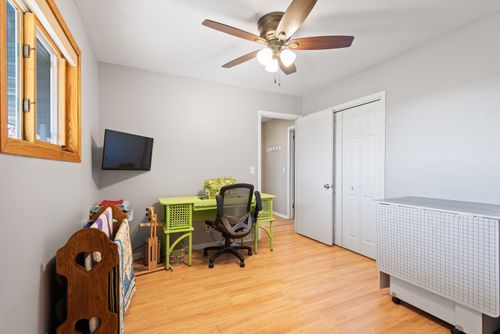 Free Bright home office featuring a colorful desk, chair, and ceiling fan. Stock Photo