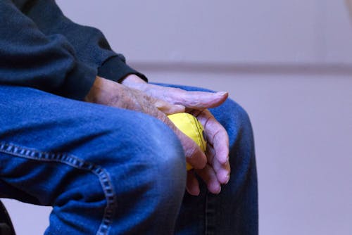 Close Up Photo of a Person Holding Yellow Ball