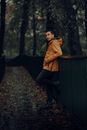 Man leaning on Metal Handrails wearing Yellow Windbreaker Jacket
