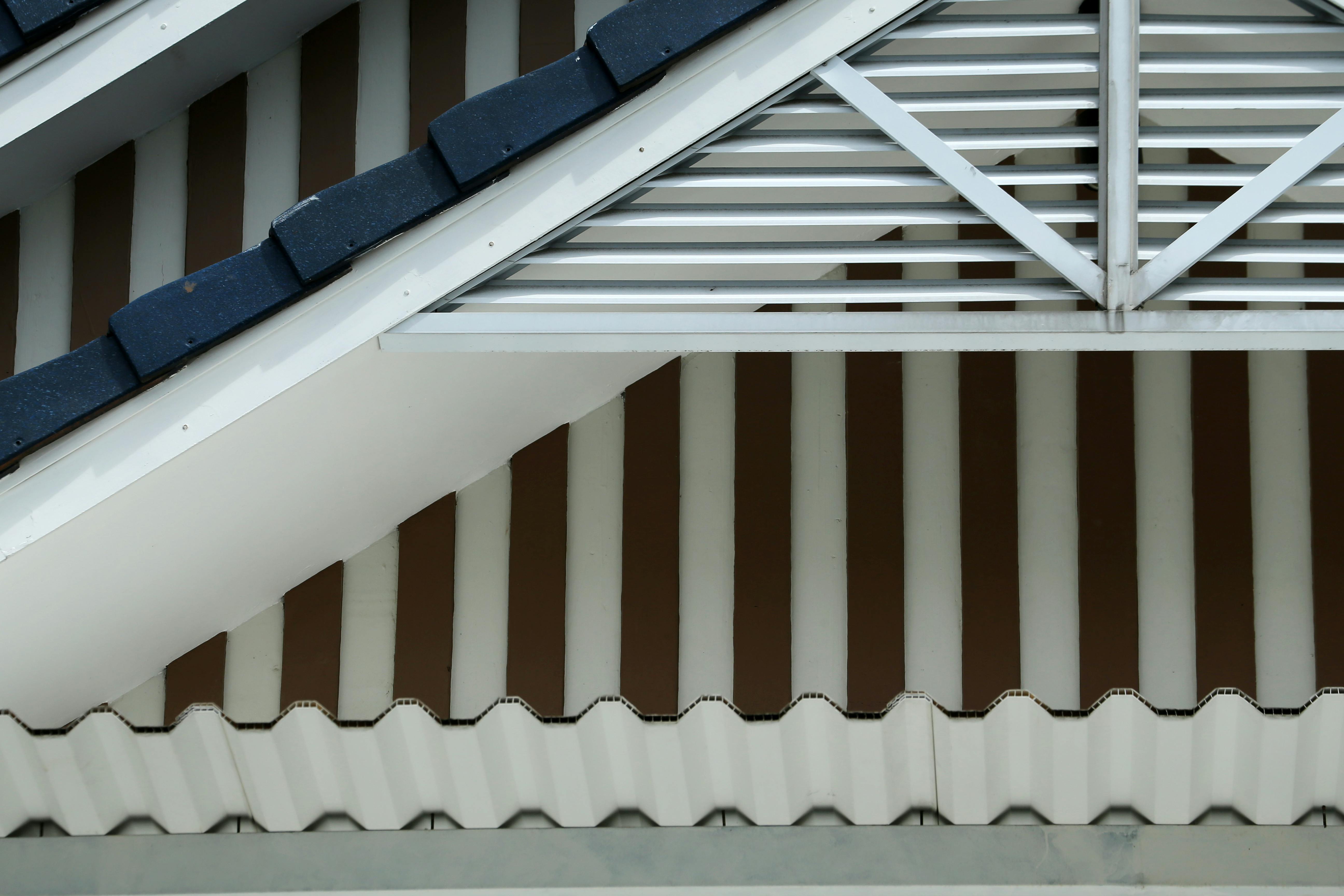 Detailed view of architectural roofing design featuring steel trusses and tiled patterns.