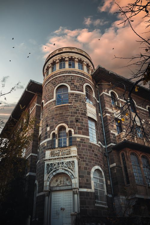 Free Low angle view of a historic stone facade in İzmir, showcasing intricate architectural details against a dramatic sky. Stock Photo