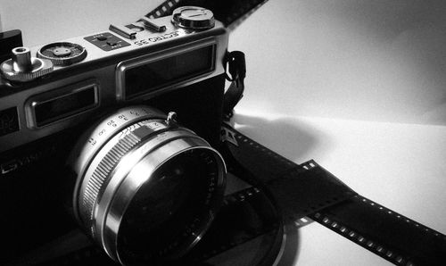 Free Retro camera and 35mm film strips in monochrome setting, ideal for analog photography enthusiasts. Stock Photo
