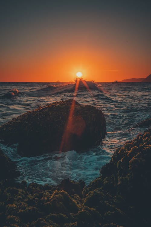 Brown Rock on Sea during Sunset