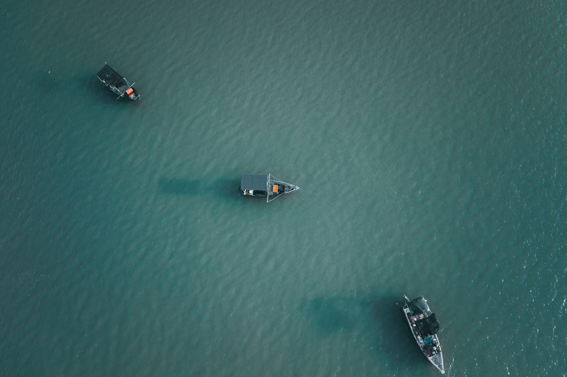 Drone shot of boats distributed evenly on the calm ocean waters in Chukai, Terengganu, Malaysia.