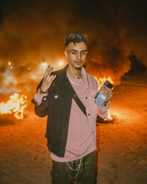 Man in Pink Shirt Holding Mobile Phones