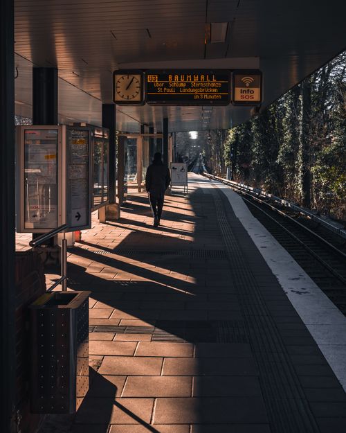 Free A person walks alone on a sunny day at a railway station in Hamburg, Germany. Stock Photo