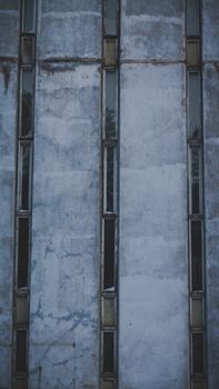 Close-up of a vertical concrete building facade featuring narrow windows.